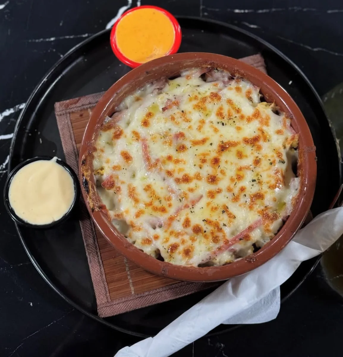Pasticcio gratiné servi avec deux sauces