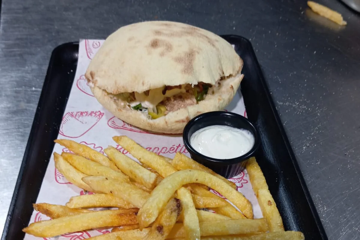 Petit sandwich rond servi avec frites et sauce