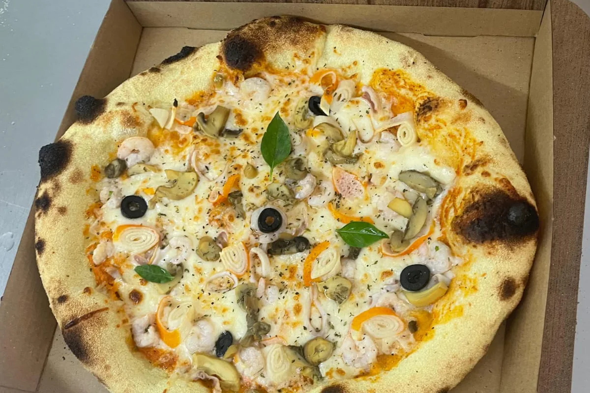 Pizza garnie de fruits de mer, champignons et olives